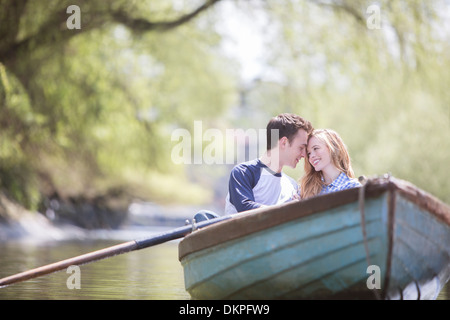 Giovane seduto in canotto sul fiume Foto Stock