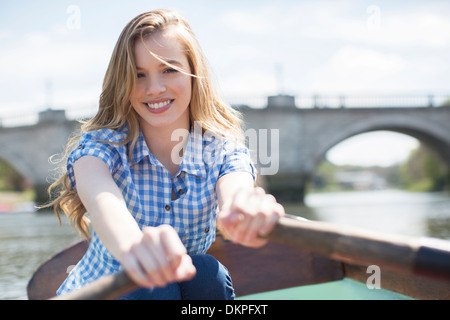 Donna barca a remi sul fiume Foto Stock