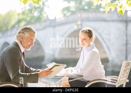 La gente di affari lavora al cafè sul marciapiede Foto Stock