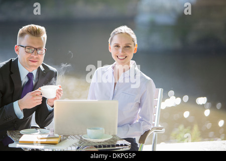 La gente di affari lavora al cafè sul marciapiede Foto Stock