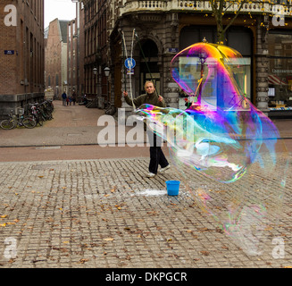 AMSTERDAM PAESI BASSI SPETTACOLI DI STRADA CON UN UOMO soffiando enormi bolle di sapone Foto Stock