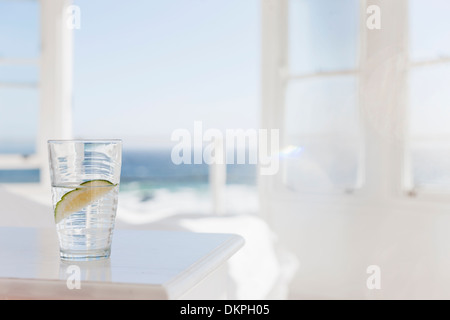 Bicchiere di acqua con calce sul tavolo Foto Stock