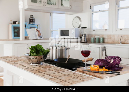 Verdure e bicchiere di vino rosso in cucina Foto Stock