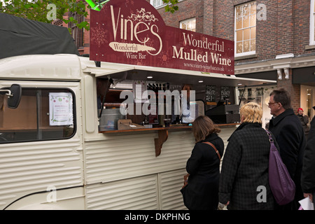 Persone turisti visitatori in linea Mobile wine bar vendita VIN brulé Wine St Nicholas Fair Christmas Market York North Yorkshire Inghilterra Regno Unito Foto Stock