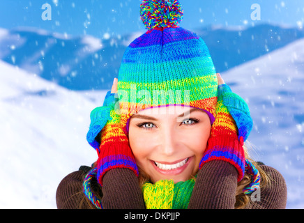 Closeup ritratto di donna graziosa orecchie di chiusura dal gelido vento, indossando colorata lana guanti e cappello, trascorrendo le vacanze invernali Foto Stock