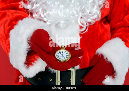 Santa Claus o Babbo Natale controllando il suo oro orologio da tasca per vedere se è il momento per il Natale. Foto Stock