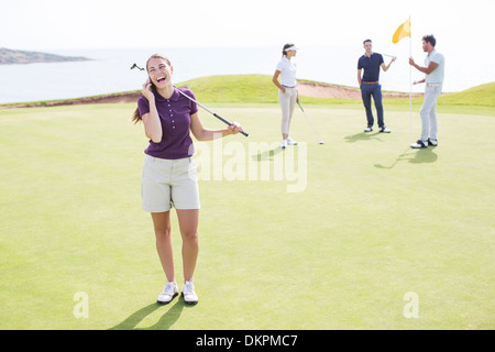 Donna che parla su telefono cellulare sul campo da golf Foto Stock