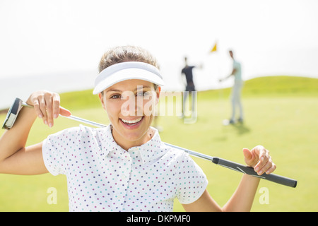 Donna che mantiene golf club Foto Stock