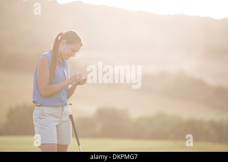 Donna con la scorecard sul campo da golf Foto Stock