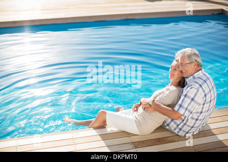 Coppia senior a rilassarci in piscina Foto Stock