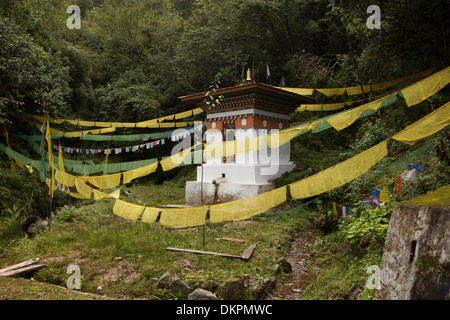 Il Bhutan, Trongsa, strada alimentati ad acqua ruota di preghiera addobbate con bandiere di preghiera Foto Stock