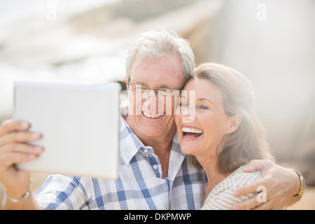 Coppia di anziani a scattare foto con tavoletta digitale Foto Stock