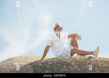 Uomo seduto sulla formazione di roccia Foto Stock