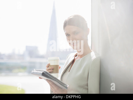 Imprenditrice di bere caffè in ufficio Foto Stock