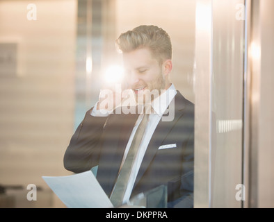 Imprenditore parlando al cellulare in ufficio Foto Stock