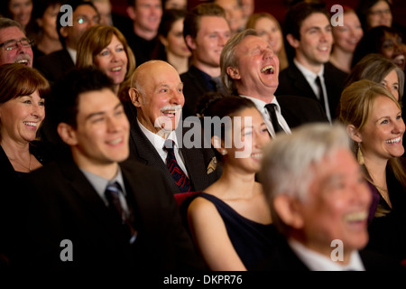 Persone sorridenti e ridere in pubblico in sala Foto Stock