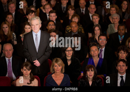 Grave man standing in pubblico in sala Foto Stock