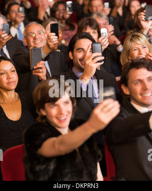 Il pubblico del teatro di filmare le prestazioni con i telefoni intelligenti Foto Stock
