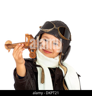 Felice ragazzo carino vestita come una guerra mondiale II riproduzione pilota con legno giocattolo aereo isolato su sfondo bianco.look vintage Foto Stock