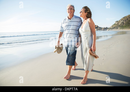 Coppia senior camminando sulla spiaggia Foto Stock