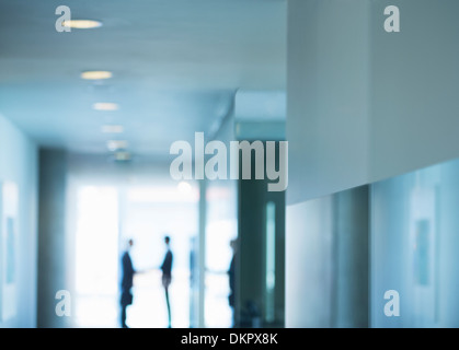 Silhouette di uomini di affari si stringono la mano in ufficio Foto Stock