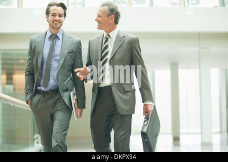 Imprenditori parlando nella lobby di office Foto Stock