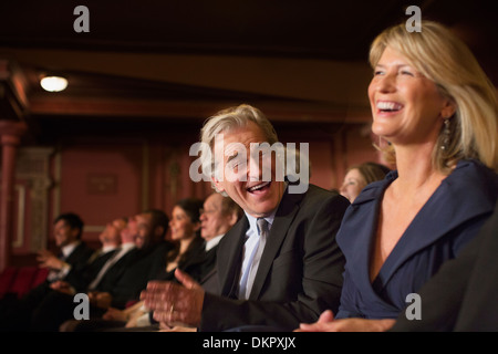 Giovane ridendo e battendo le mani in teatro Foto Stock