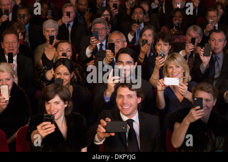 Il pubblico del teatro di filmare le prestazioni con i telefoni intelligenti Foto Stock