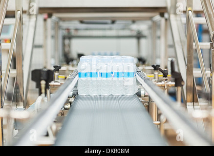 Bottiglie di acqua sul nastro trasportatore in fabbrica Foto Stock