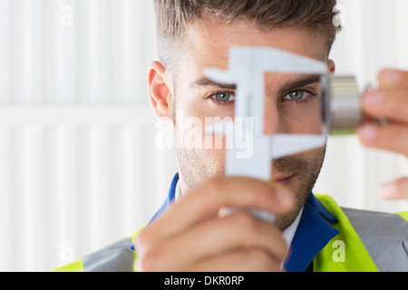 Lavoratore utilizzando i calibri in fabbrica Foto Stock