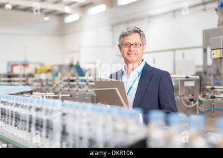 Supervisor sorridente in impianto di imbottigliamento Foto Stock