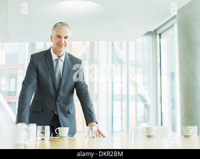 Imprenditore in piedi in ufficio Foto Stock