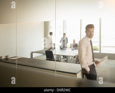 Imprenditore in piedi in ufficio Foto Stock