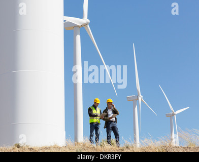 I lavoratori parlano da turbine eoliche nel paesaggio rurale Foto Stock