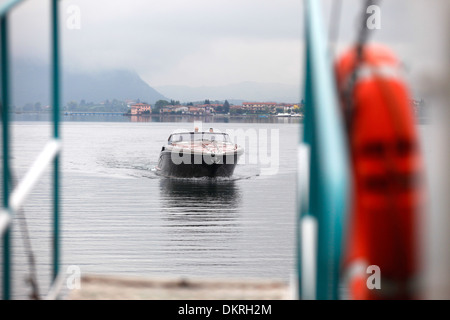 Un Rivarama super yacht vicino alla fabbrica di Riva in una nebbiosa Lago d'Iseo a Sarnico, Italia. Foto Stock