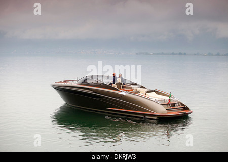 Un Rivarama super yacht vicino alla fabbrica di Riva in una nebbiosa Lago d'Iseo a Sarnico, Italia. Foto Stock