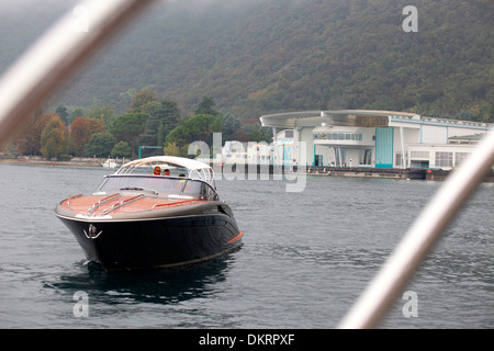 Un Rivarama super yacht vicino alla fabbrica di Riva in una nebbiosa Lago d'Iseo a Sarnico, Italia. Foto Stock