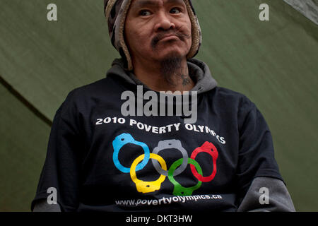 Feb 15, 2010 - Vancouver, British Columbia, Canada - Centinaia di senzatetto e di povertà manifestanti utilizzando l'Olympic spotlight per il loro vantaggio invaso una grande partita vacante in Vancouver è notoriamente scarsa e Hastings Street ed eretta una tenda città. L uomo indossa un '2010 povertà Olypmics' T shirt in segno di protesta contro i Giochi Olimpici Invernali. Il numero di senzatetto in Vancouver ho Foto Stock