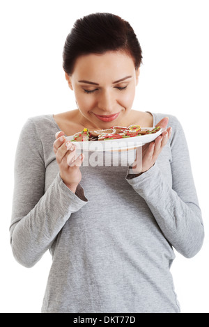 Bella giovane donna con i cookie su una piastra. Isolato su bianco. Foto Stock