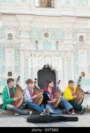 Quattro giovani bandurists ucraino banduras suonare e cantare di fronte la Cattedrale di Santa Sofia a Kiev, la capitale di Ucraina. Foto Stock