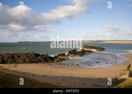 Isola di Llanddwyn Anglesey North Wales UK guardando attraverso Malltraeth Bay a Penrhos spiaggia con piccola baia in primo piano il Percorso Costiero Foto Stock