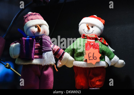 Pupazzi di neve a maglia decorazioni in vendita su un mercato di Natale Foto Stock