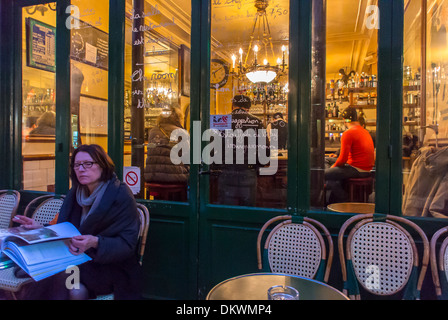 Parigi, Francia, donna seduta da sola sul French Bistro Restaurant Café Terrace nel Marais, "le Petit Fer à Cheval", notte, Bar terrazza frontale, luci Foto Stock