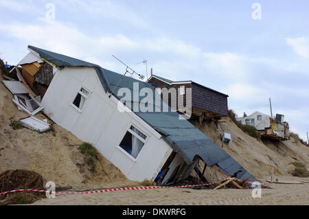 Beach home crollato giù sulla spiaggia o appendere in precario equilibrio sopra il bordo di dune causato da insolitamente alta marea surge storm lavato via la terra sotto di esso. Scena domenica 8 dicembre 2013. Hemsby, Norfolk Foto Stock