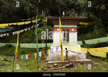 Il Bhutan, Trongsa, strada alimentati ad acqua ruota di preghiera con la preghiera i flag su Yotang La strada Foto Stock