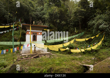 Il Bhutan, Trongsa, strada alimentati ad acqua ruota di preghiera con la preghiera i flag su Yotang La strada Foto Stock