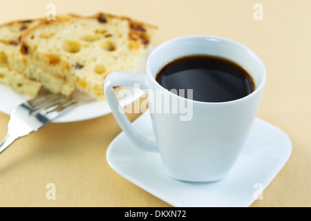 Foto orizzontale di caffè appena fatto in bianco cup italiana con fette di torta su una piastra bianca lungo con forca Foto Stock
