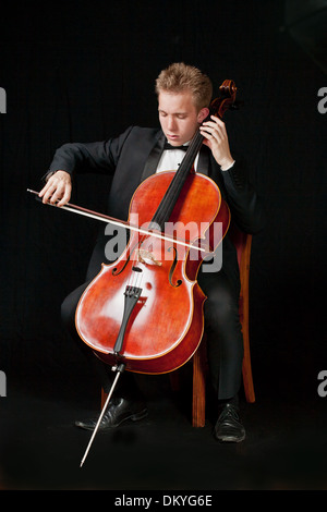 Giovani caucasici lettore di violoncello con sfondo nero Foto Stock