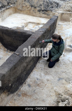 Potsdam, Germania. Decimo Dec, 2013. Archeologo Evelyn Steffens lavora presso un sito di scavo sui terreni di un ex giardino del mercato a Potsdam, Germania, 10 dicembre 2013. I resti ben conservati di circa 40 case dal tempo dell'Impero Romano furono scoperti finora. Il sito di scavo è di circa 30.000 metri quadri di grandi dimensioni. Foto: Ralf Hirschberger/dpa/Alamy Live News Foto Stock