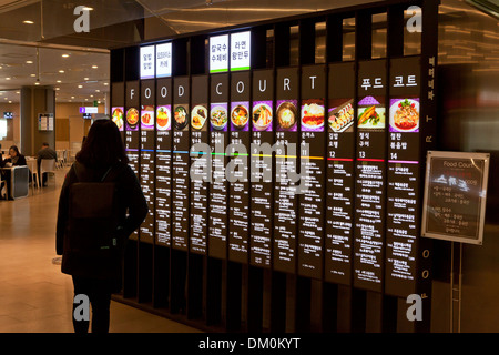 Donna lettura food court menu - Seoul, Corea del Sud Foto Stock